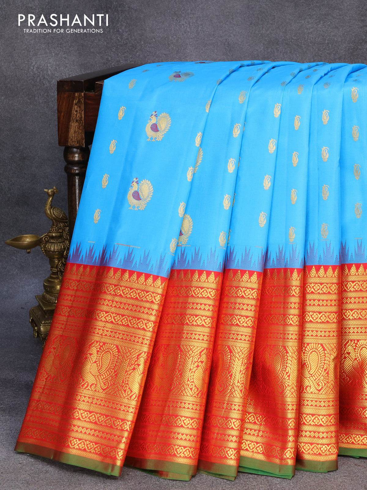 Pure gadwal silk saree light blue and red with allover zari woven buttas and temple design long annam zari woven border